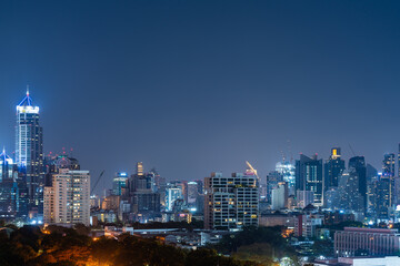 Fototapeta na wymiar Night Bangkok panoramic city view, green trees and skyscrapers. Copy space