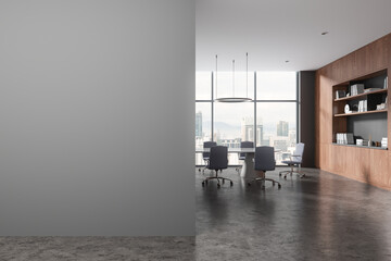 Gray board room interior with bookcase and blank wall