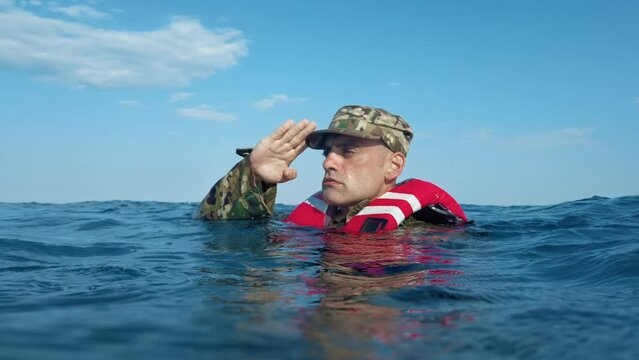 Soldier Salutes Underwater in the sea 
