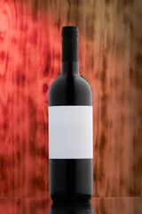red wine bottle next to barrel with white etiquette on dreamy vine back drop
