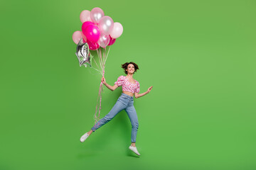 Fototapeta na wymiar Full body photo of lovely young lady running hold air balloons dressed stylish pink cherry print garment isolated on green color background