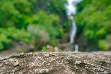 Surface of stone on the background of waterfall in jungle 