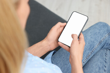 Woman using smartphone at home, closeup. Space for text