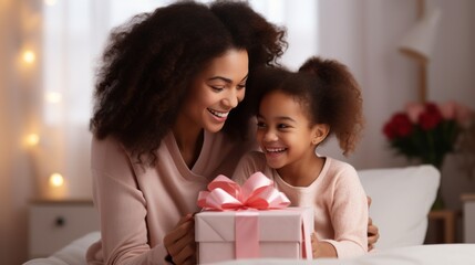Happy mother's day. african american baby daughter giving gift box to her mom for holiday at home - Powered by Adobe