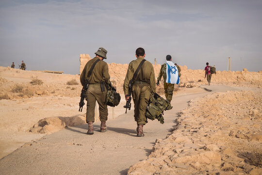 Back shot of several soldiers of israel army walking with israel national flag. Military man walking with other soldiers. War tactical exercise. infantry retreat from positions