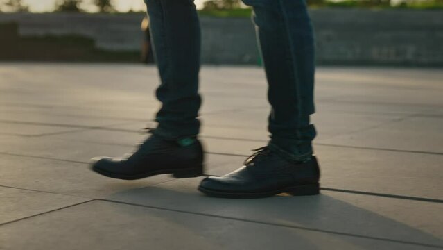 Male legs in classic shoes close-up. An unrecognizable man walks along the sidewalks in the city