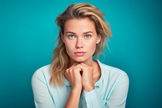 Mujer rubia con gesto de desconfianza, con las manos cogidas
