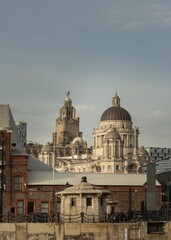 Obraz premium View of buildings on Liverpool's waterfront. One of the buildings which make the 'Three Graces' the other two, the Cunard building - the Royal Liver building. See through Royal Albert Dock Liverpool. 