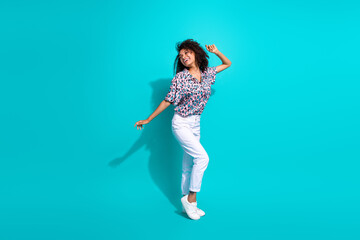 Full length photo of lovely glad girl wear stylish outfit rejoice seasonal sale look up empty space isolated on cyan color background