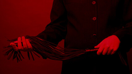 Male dominant holds a leather whip Flogger for hard BDSM sex with spanking