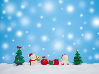 Snowman in the town with shiny light for Christmas and New Year holidays background, Winter season, falling snow, Copy space for Christmas and New Year holidays greeting card.