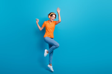 Full length photo of good mood ecstatic woman wear orange t-shirt jeans listen playlist in...