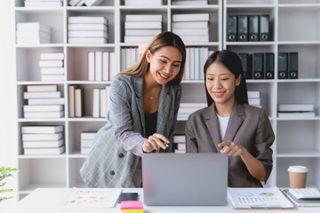 Two Asian businesswoman teamwork discussing and using laptop. Two Asian business women are talking and consulting.