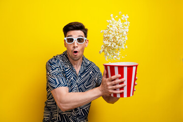 Portrait of astonished funny guy wear stylish shirt in 3d glasses catching popcorn staring at movie isolated on yellow color background