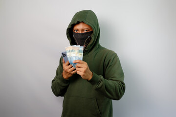 Hacker steal from the mobile phone and holding paper money isolated on white background.