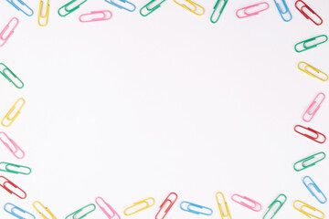 Frame of colorful paperclip on white background