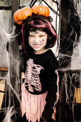 Pretty little girl dressing up as a witch in a Halloween setting - 661789166