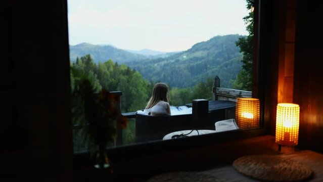 view from the window of the house on the girl taking a bath, bathing on the terrace against the background of the mountains
