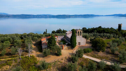 Widok z lotu ptaka na starożytny kościół i ruiny fortecy Parco Naturale dell'Isola Maggiore PG, 06069. Wyspa na jeziorze Maggiore we Włoszech. - obrazy, fototapety, plakaty