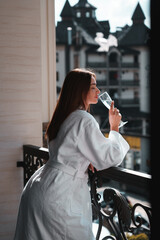 Close up of young couple in bathrobe standing on hotel balcony against mountain background