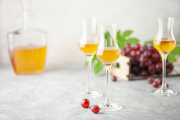 Grape vodka. Strong alcoholic drink in glasses on the table. Fresh grapes