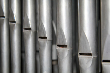 Viele Orgelpfeifen stehen nebeneinander in einer Orgel über einen Blasebalk.
