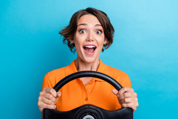 Photo of excited impressed lady wear orange t-shirt driving automobile isolated blue color...