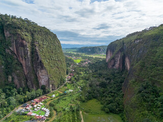 Fototapeta na wymiar Aerial view of Harau Valley, a popular tourist spot featuring mountains and rice fields at Sumatra island, Indonesia.