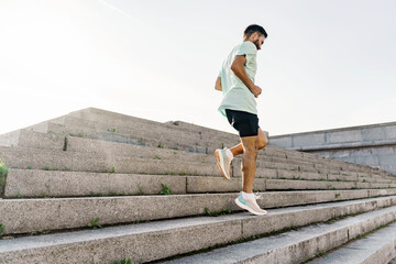 Athlete trainer exercises to warm up muscles. Hobby jogging in running shoes. Mental and psychological health. A healthy man who trains actively interval training.