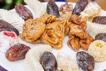 Assortment of chebakias, Moorish pasta and dates, on a white plate