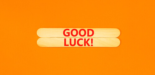 Good luck symbol. Concept words Good luck on wooden stick. Beautiful orange table orange background. Business, motivational good luck concept. Copy space.