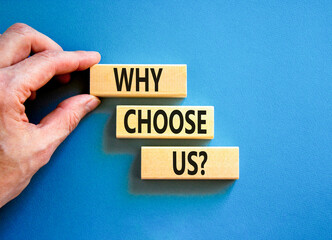 Why choose us symbol. Concept word Why choose us on beautiful wooden block. Businessman hand. Beautiful blue table blue background. Business motivational why choose us concept. Copy space.