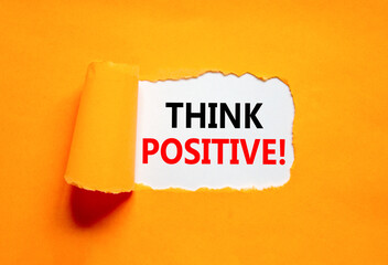 Think positive symbol. Concept words Think positive on beautiful white paper. Beautiful orange table orange background. Business, motivational think positive thinking concept. Copy space.