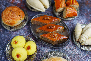 Traditional Azerbaijan holiday Novruz background with green semeni,traditional azerbaijan sweets,shekerbura,qogal,paxlava,mutaki and different nuts and sweets,top view,space for copy