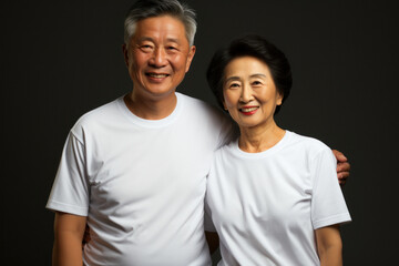 Obraz premium Portrait of a senior Asian couple in casual clothes on dark gray background