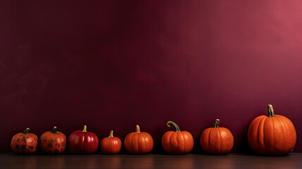 Naklejka na ściany i meble A group of pumpkins on a dark maroon background or wallpaper