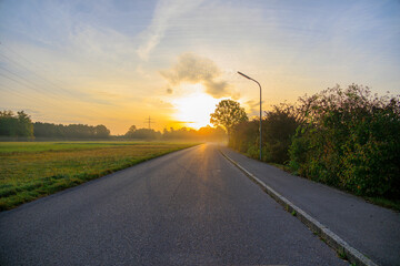 Morning sun over the road between meadows in Siebenbrunn near Augsburg
