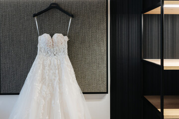 Bridal dress hanging on display in the hotel room before the wedding