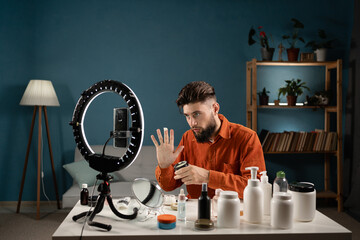 Bearded man blogger is showing how to use cosmetics. Business online influencer on social media...