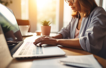 Closeup hands of business woman working on laptop. Woman using laptop at home office. Blogger writing blog from cozy home. Work from home. Creating digital content comfortably at home.