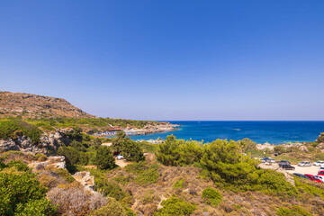 Fototapeta na wymiar Gorgeous views of mountainous natural landscape of Mediterranean coast with beaches, hotels and parking for vehicles on island of Rhodes. Greece. Europe.