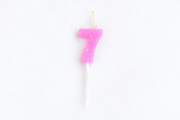 Purple candle number 7 on cement wall background, Birthday candle