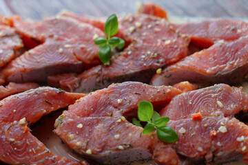 Red fish is cut into steaks and covered in creamy sauce.