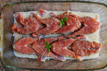 Red fish is cut into steaks and covered in creamy sauce.