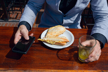 top view of caucasian hands of unrecognizable man having breakfast and holding phone