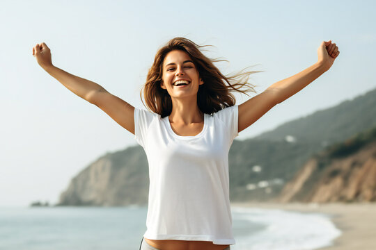 Happy young woman on the beach laughing and doing a spontaneous gesture