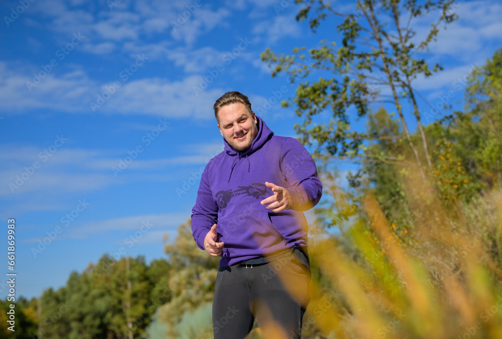 Canvas Prints Young attractive man wearing a purple hoodie pointing to the camera