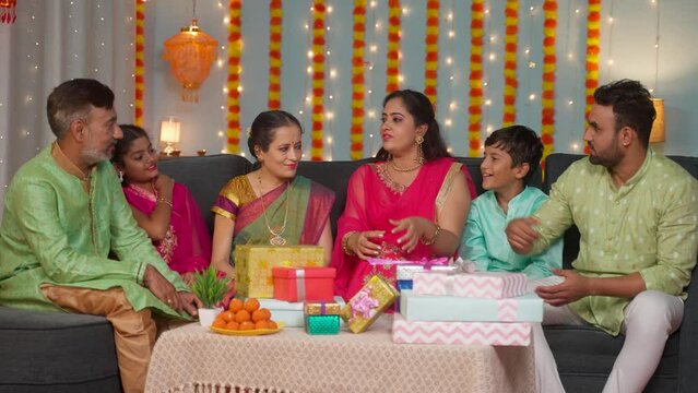 Group of Happy Indian Joint family member spending time together by sharing memories at home during diwali festival celebration - concept of Family reunion, Festive Gathering and Joyful Moments