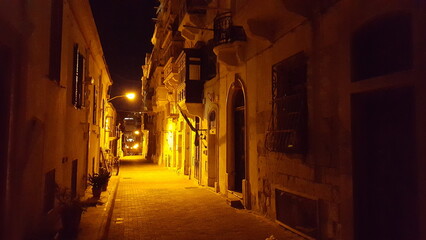 A dimly lit narrow street at night