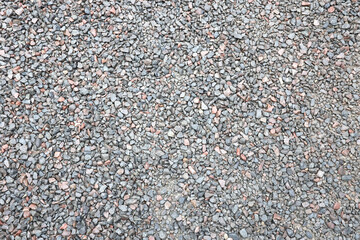 Close up of muddy puddle with small stones on wet surface. Background texture with top view